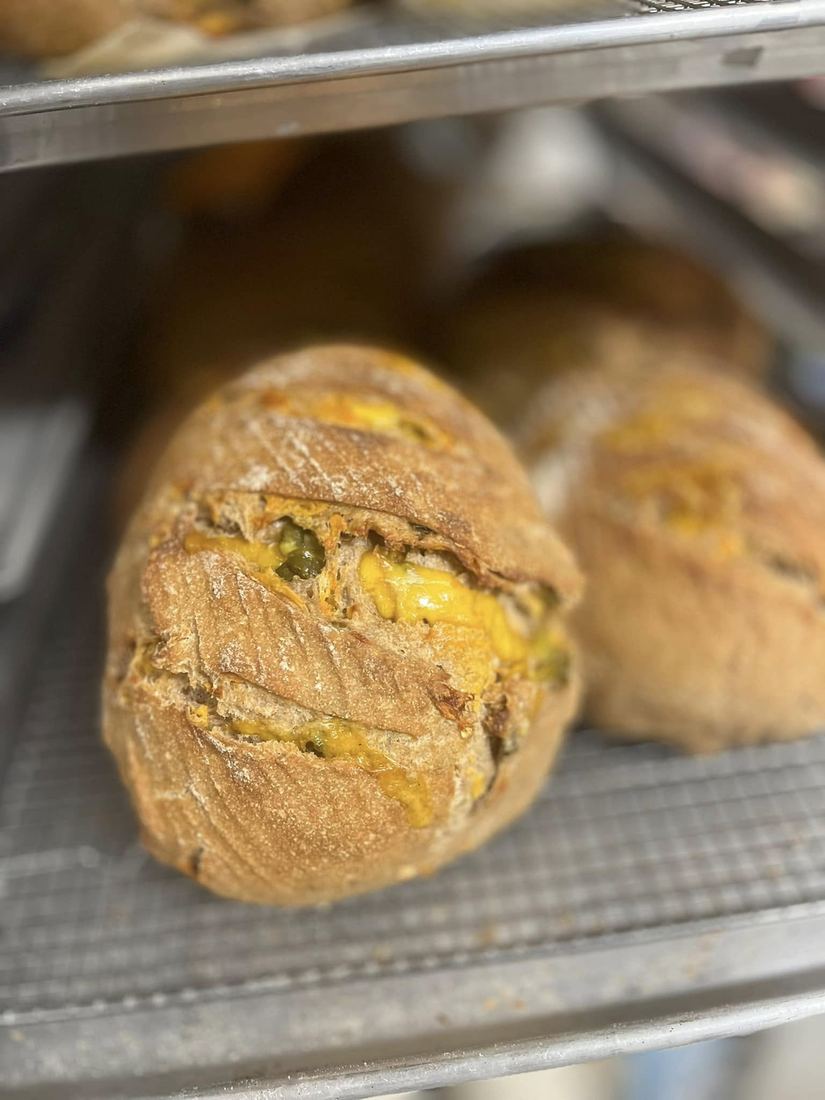 Small filled loaves browning on an oven rack.