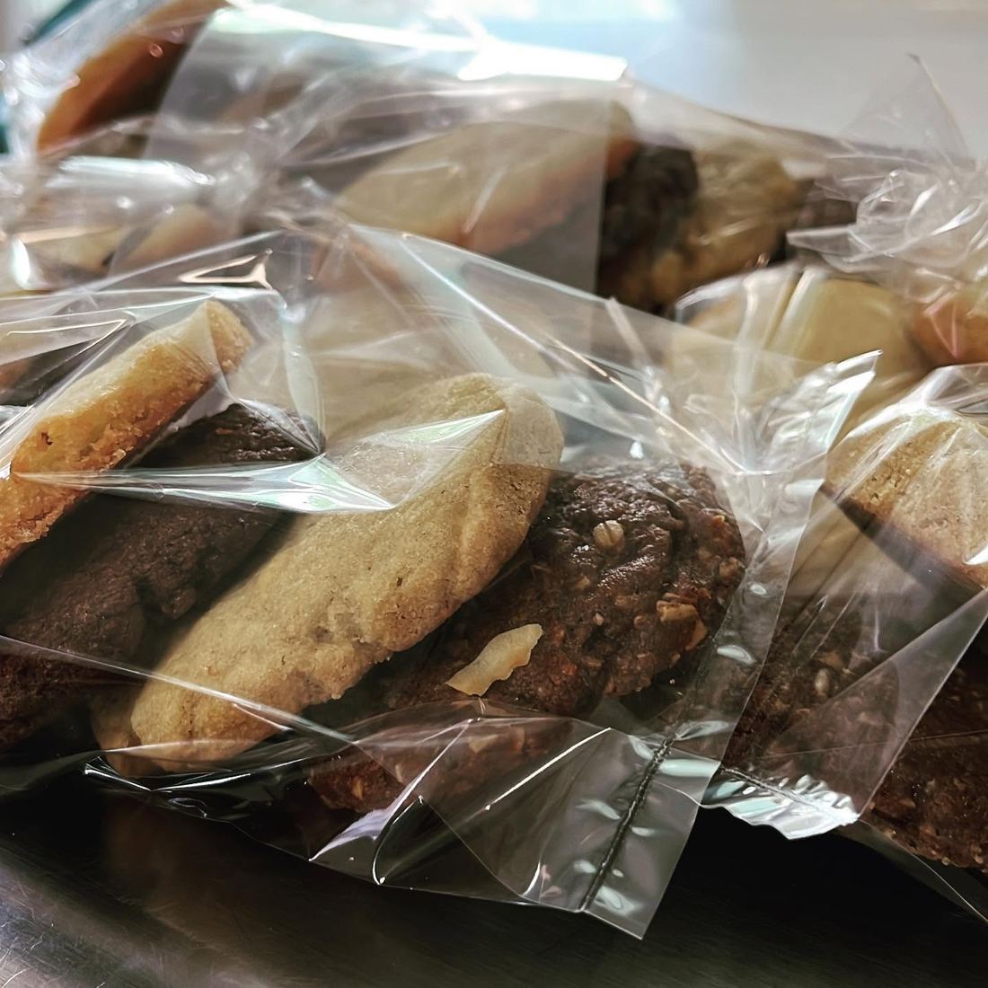 Individually wrapped cookies stacked together on a metal tray.